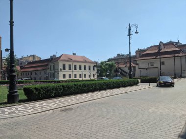 Krakow, Polonya - 30 Haziran 2021: Gri tuğla taş sokak ve binalar ve çitli kaldırım