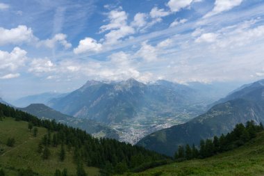 Panoramik manzara, arka planda dağlar ve çayırlar, güzel, güneşli bir günde çimenler olan rahatlatıcı dağ manzarası.