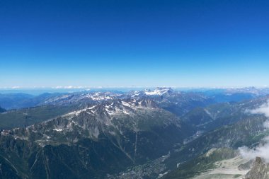 Uzaktaki Aiguille du Midi 'nin Avrupa Alpleri ve Chamonix üzerindeki hava manzarası. Dağlar karla kaplı.