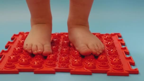 Masaje de pies, el niño pisa una alfombra de masaje descalzo, primer plano — Vídeos de Stock