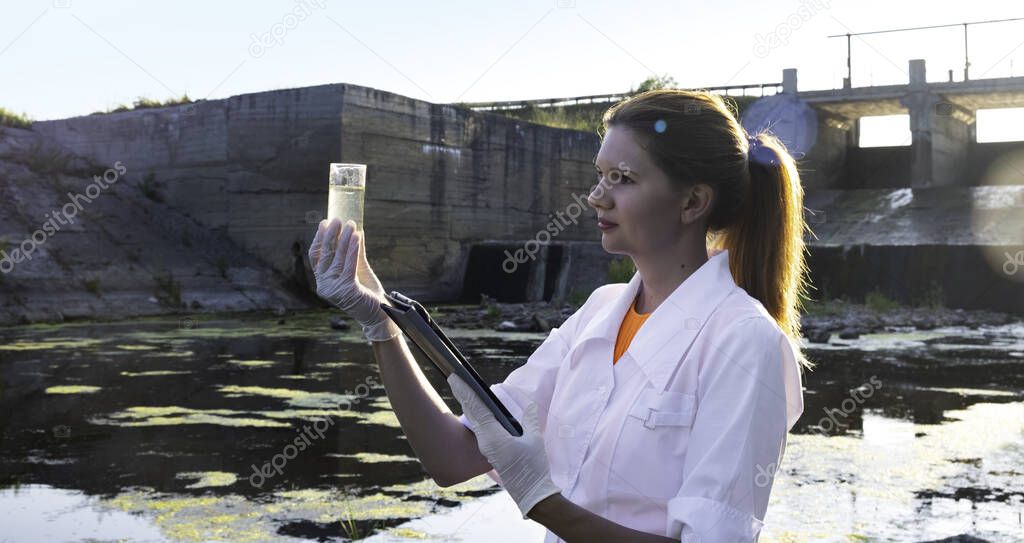 a female ecologist takes water samples for contamination, the concept of ecology.