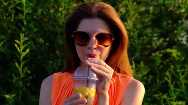 Słodkie dziewczyna pije letni koktajl, z plastikowej szklanki, — Wideo stockowe