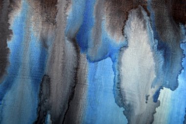 Aşınmış bir yüzeydeki mavi lekelerin koyu arkaplanı.