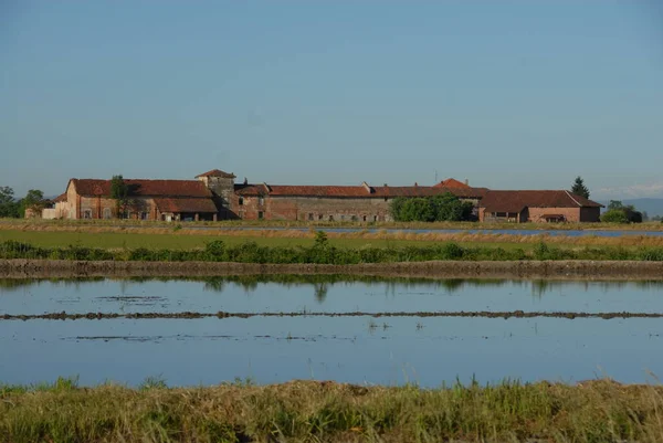 Piedmont 'un sular altında kalan çeltik tarlasında Mayıs ayında Vercelli ili güzel yansımaları ve renkleri olan bir su aynası olarak görülür..