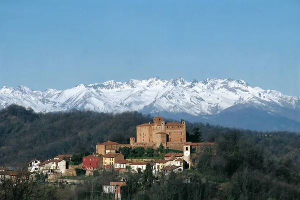 在都灵附近的山上有塔和城堡的古老的巴尔达萨诺村庄和皮埃蒙特的阿尔卑斯山 免版税图库图片