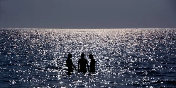 Gün batımında Cilento Denizi 'nde gölgeli erkek çocukları..
