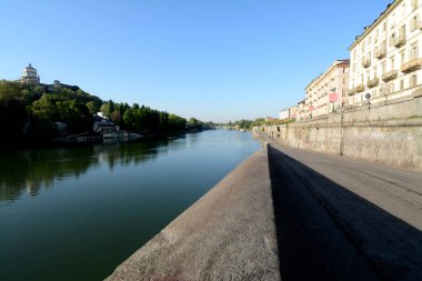 Torino 'daki Po nehri Murazzi tarafından fotoğraflandı. Nehirde yüzen kanocular Monte dei Capuccini 'nin üzerinde durduğu tepenin altında yelken açarlar..