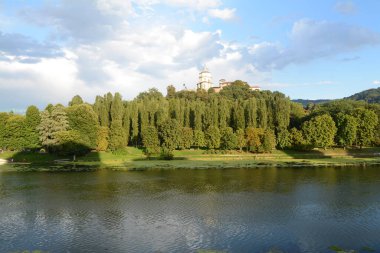 Torino 'daki Po nehri Murazzi tarafından fotoğraflandı. Nehirde yüzen kanocular Monte dei Capuccini 'nin üzerinde durduğu tepenin altında yelken açarlar..