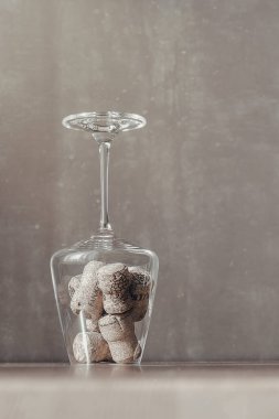 Şarabın mantarı şeffaf bir bardakta güneşin tozunda bir masanın üzerinde.