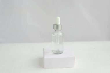 Doğal kozmetik ürünleri için cam kavanoz beyaz arka planda su damlaları var. Moda minimalist soyut koleksiyonu. Bir kadının güzelliği. Doğal arkaplan.