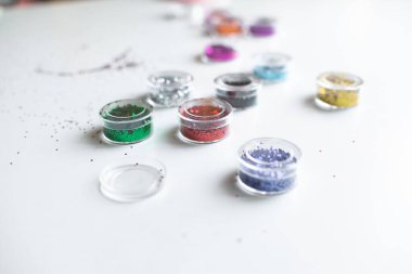 Beyaz bir masada çok renkli parlaklıklar var. El işi, dekorasyon ve bayram için dekorasyon malzemeleri. Çocukların gelişimi.