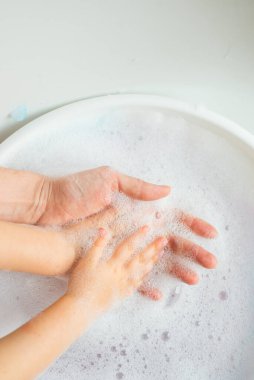 Beyaz köpüklü kadın ve çocukların elleri. Hijyen, temizlik, cilt bakımı.