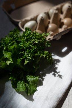 Ekolojik kağıt tepside sülün yumurtası avlıyorum. Bahçeden taze otlarla. Kümes hayvanları, gün ışığında sert gölgeler..
