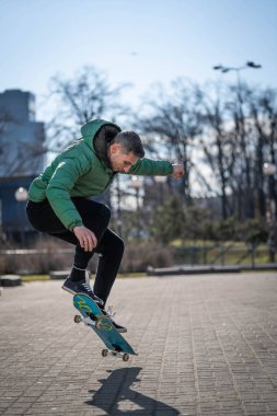 Adam sokağın aşağısında kaykayla yarışıyor.