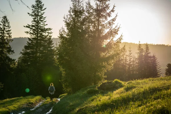 Bir kız sıcak güneş ışınlarıyla dolu bir yolda yürüyor.