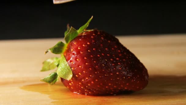 Die Erdbeere wird mit dem Messer geschnitten — Stockvideo