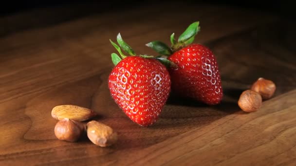 Stilleven macro met twee aardbeien en noten — Stockvideo