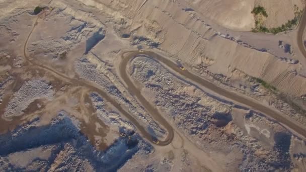 Industriële vrachtwagens beweegt langs de weg in het zand steengroeve — Stockvideo