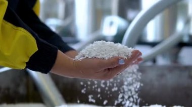 Plastik granüller elden dökülür. Plastik granüller, boya, polimer granüller plastik ürünlerin üretimi için kullanılır.