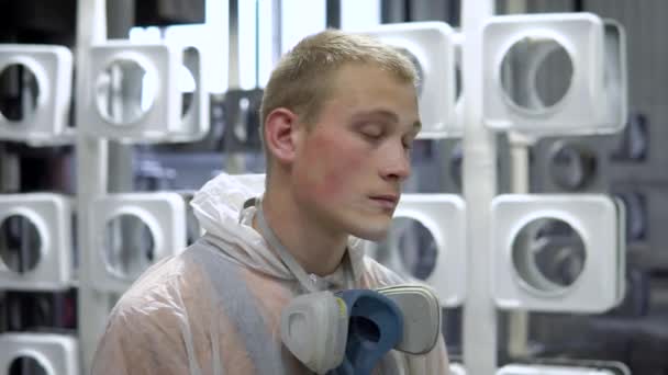 Portret van een man met een masker in de verfwinkel. Hij draagt een beschermend masker en een beschermende mantel, hij kijkt naar de camera — Stockvideo