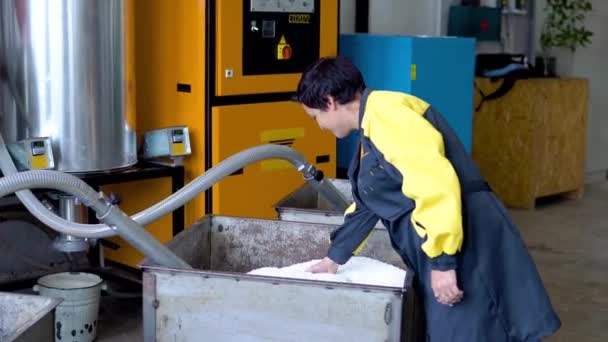 Trabajador de la planta de producción Trabaja con cargador de manguera de vacío succión de gránulos de plástico virgen blanco del tanque en taller de fábrica — Vídeos de Stock