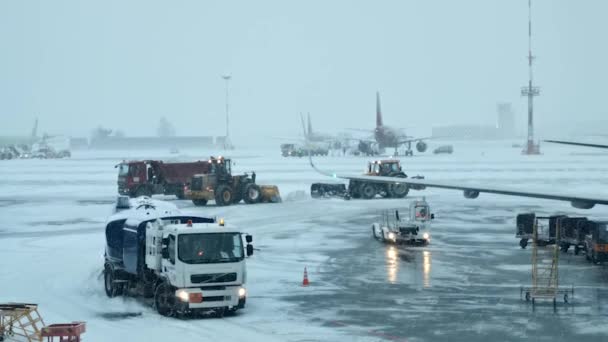 Petrohrad, Rusko. 25. prosince2020. Pulkovo letiště. Vyklízení letiště od sněhu během sněhové bouře. čistí ranvej od sněhu. Odklízení sněhu s buldozery z letištních odbavovacích ploch. — Stock video