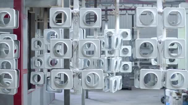 Line for painting metal products in white color coating. Square metal products with a round hole hang on mounts after powder painting — Stock Video