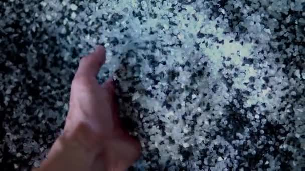 Kunststof zwart-wit granulaat wordt uit de hand gegoten. Kunststof korrels, kleurstoffen, polymeer korrels worden gebruikt voor de productie van kunststof producten — Stockvideo