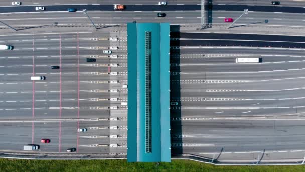 Autopistas de peaje en la amplia carretera. A través del punto pasa un gran número de camiones y coches. Vista de arriba hacia abajo desde el quadcopter — Vídeos de Stock