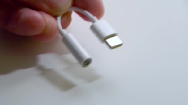 Malý adaptér z USB konektoru typu C 3.5 jack na mužské ruce na bílém pozadí. SOFT zaměření. Malý DOF — Stock video