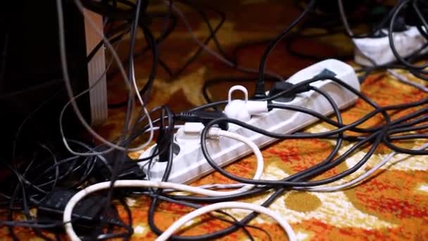 Auf der Diagonale befindet sich ein weißer Steckdosensplitter mit einem Schaltknopf, in dem Stecker verschiedener Geräte und Kabel enthalten sind. — Stockvideo