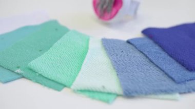 Kumaş ve dikiş işleriyle terzi kadın. Tekstil endüstrisi, dikiş, kumaş mağazası dokusu, desenler, dikiş aşınması, mendiller, iğne.