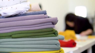 Kumaş ve dikiş işleriyle terzi kadın. Tekstil endüstrisi, dikiş, kumaş mağazası dokusu, desenler, dikiş aşınması, mendiller.
