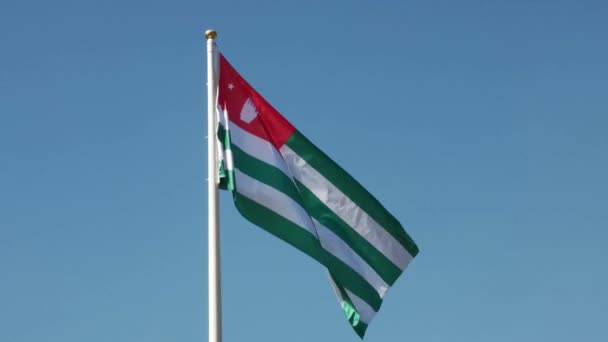 Flaga Abchazji rozwija się na tle błękitnego nieba — Wideo stockowe