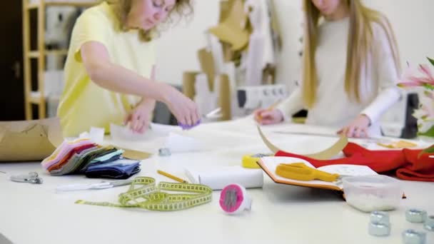 Dos hermosas mujeres que trabajan juntas en el lugar de trabajo en el taller. Concepto de pequeña empresa y creatividad — Vídeos de Stock