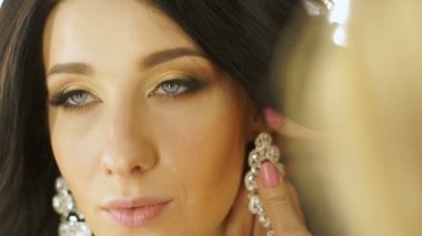 Stilist modeli kulaklarında küpe takıyor