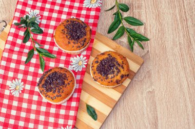 Çikolatalı kek ve fındıklı kek, arka planda ev yapımı fırın. Ahşap bir masada yaban mersinli kek. Tahtada taze böğürtlen ve tatlı börek var..
