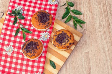 Çikolatalı kek ve fındıklı kek, arka planda ev yapımı fırın. Ahşap bir masada yaban mersinli kek. Tahtada taze böğürtlen ve tatlı börek var..