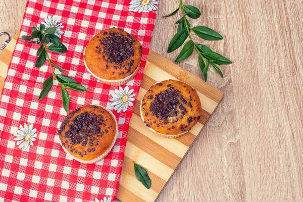 Çikolatalı kek ve fındıklı kek, arka planda ev yapımı fırın. Ahşap bir masada yaban mersinli kek. Tahtada taze böğürtlen ve tatlı börek var..