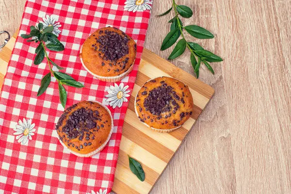 Çikolatalı kek ve fındıklı kek, arka planda ev yapımı fırın. Ahşap bir masada yaban mersinli kek. Tahtada taze böğürtlen ve tatlı börek var..