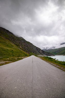 Toplu taşıma servisinin sarı vagonu. İsviçre Alplerindeki Lac de Moiry 'nin üstündeki otobüs durağında. Grimentz Vallis, CH İsviçre.