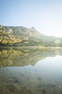 İsviçre, Wallis 'teki Fiesch yakınlarında Bettmer Gölü manzarası. İsviçre 'de gün doğumunda gölün yansıması