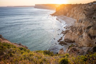 Lagos, Algarve Portekiz 'deki Praia do Camilo' ya güneş doğarken göz kamaştırıcı bir manzara. Kayalar, kayalıklar ve okyanustaki oluşumlar. Doğal hazine. Portekiz