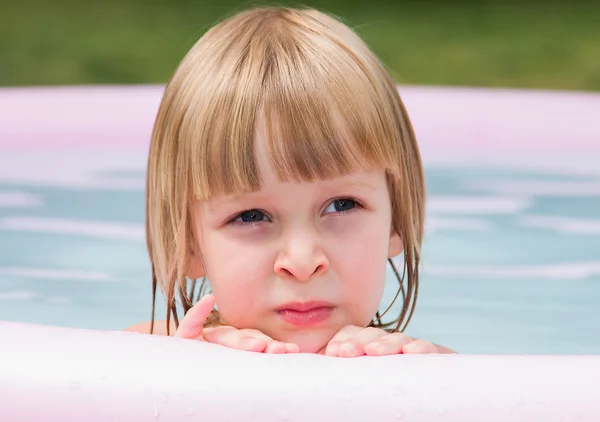 Thoughtful little girl in inflatable pool Royalty Free Stock Photos