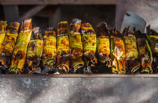 Kleefrijst verpakt in bananen bladeren grill. — Stockfoto