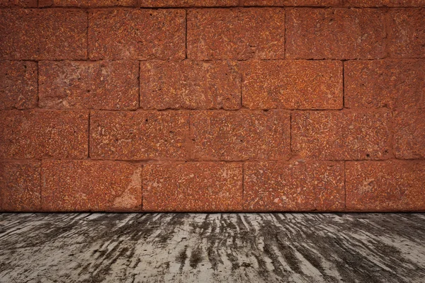Laterite taş duvar ve çimento zemin.