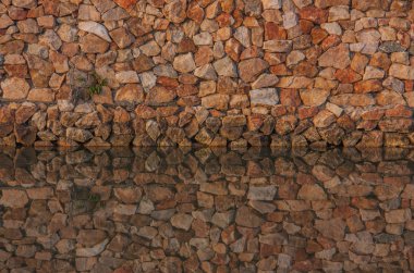 Duvar taşları ve su yansıma.
