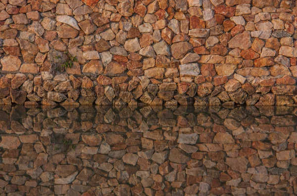 Duvar taşları ve su yansıma.