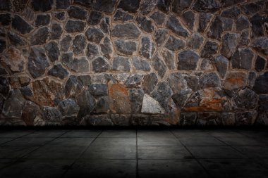 Taş duvar ve çimento zemin.