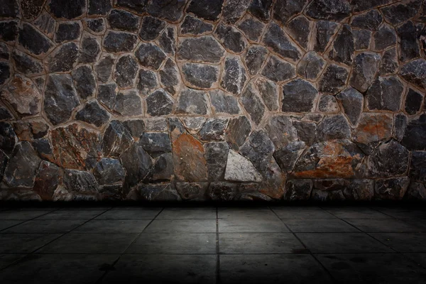 Taş duvar ve çimento zemin.